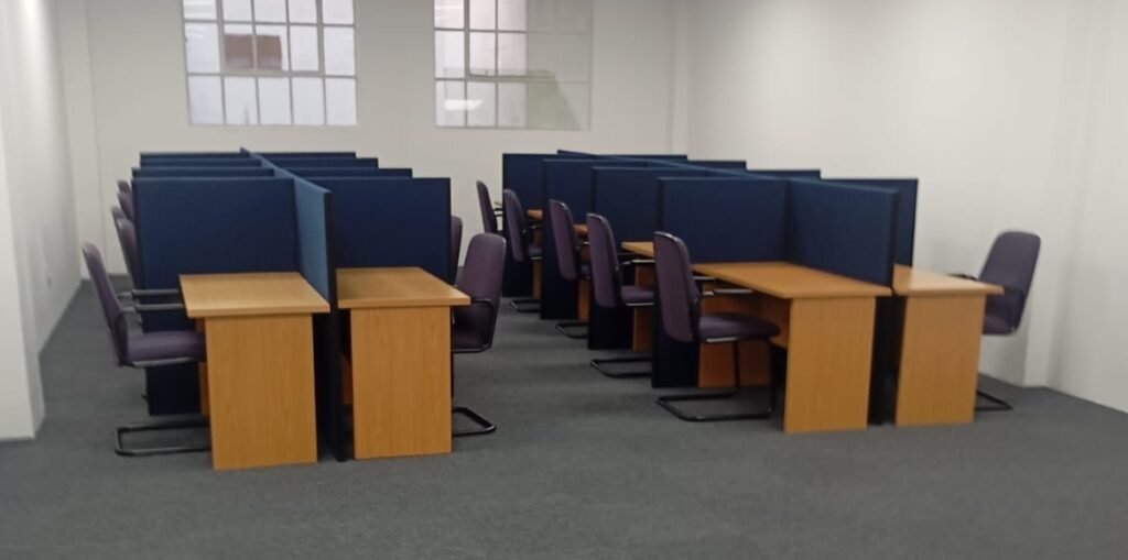 Open plan office furniture setup with desks and chairs in a corporate workspace